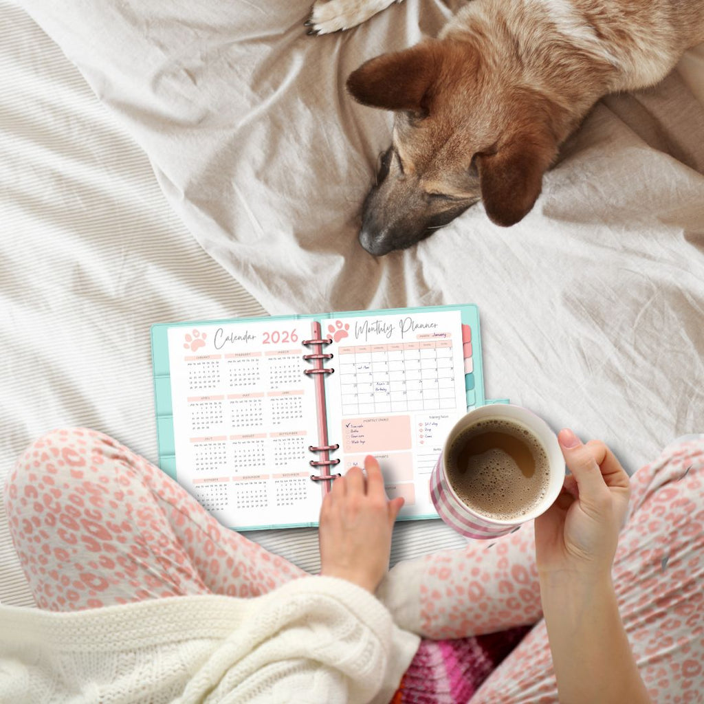girl using dog planner on bed with dog