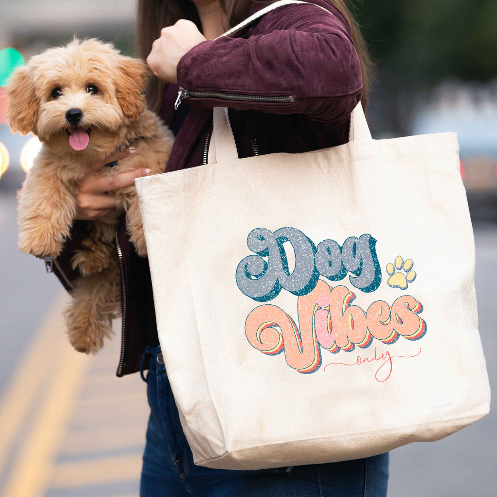 woman carrying 'dog vibes only' tote bag and dog