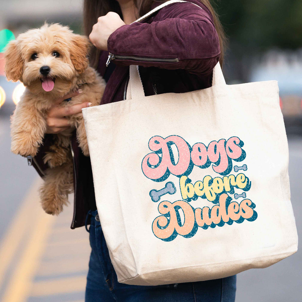 woman carrying 'Dogs before dudes' tote bag and dog