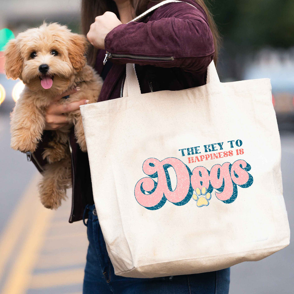 Woman carrying 'The key to happiness is dogs' tote bag and dog
