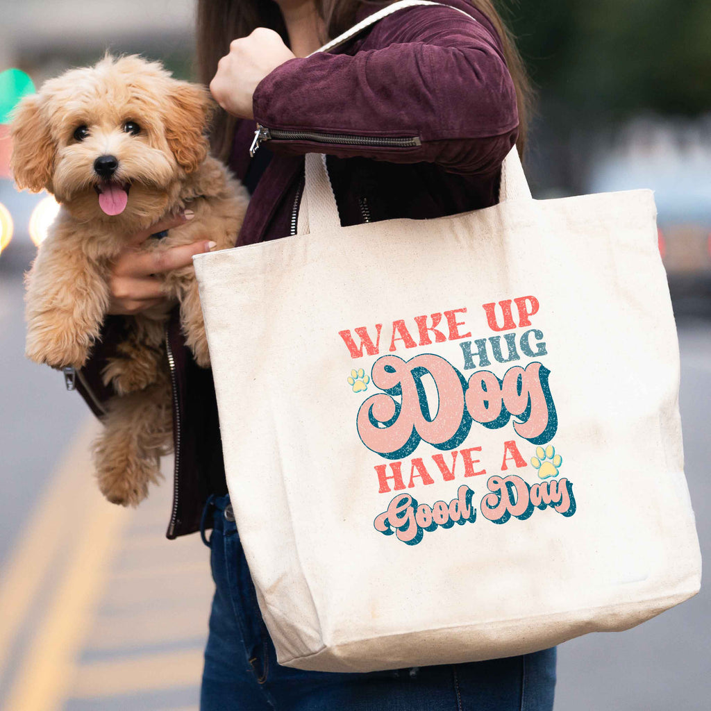 woman carrying 'wake up, hug dog, have a good day' tote bag and dog