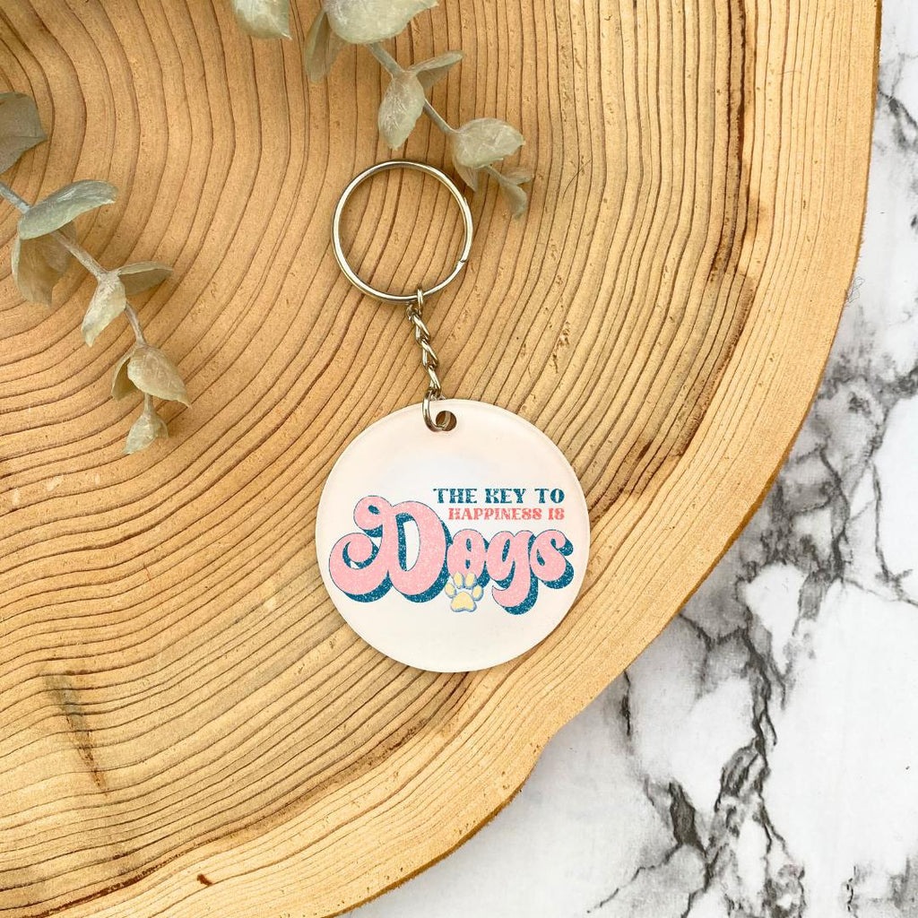 'The Key to Happiness is Dogs' Acrylic Keyring - wooden background